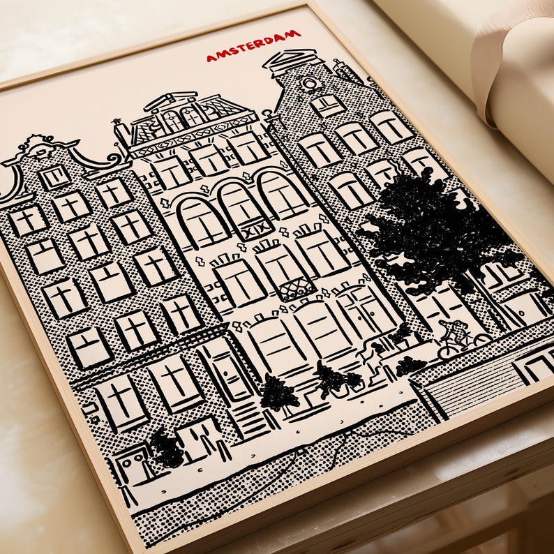 May include: Framed black and white illustration of Amsterdam buildings. The artwork features detailed architectural drawings of canal houses, with the city name in red at the top. The style is reminiscent of a comic book.