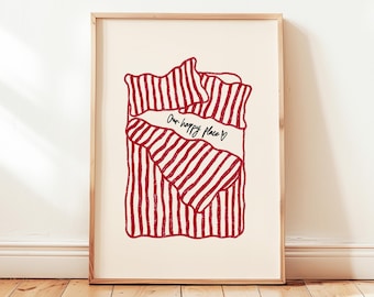 May include: A framed art print featuring a red and white striped design resembling a bed with bedding. The words "Our happy place" are written across the bedding in black script.