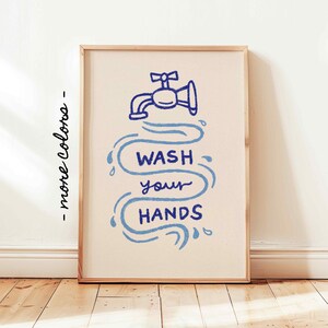May include: A framed print with a blue illustration of a faucet and water flowing with the text "WASH your HANDS" in blue.