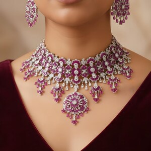 May include: A dazzling jewelry set featuring a necklace and matching earrings. The necklace and earrings are adorned with a combination of white gemstones and vibrant pink stones, creating a luxurious and eye-catching design. The set is perfect for special occasions.