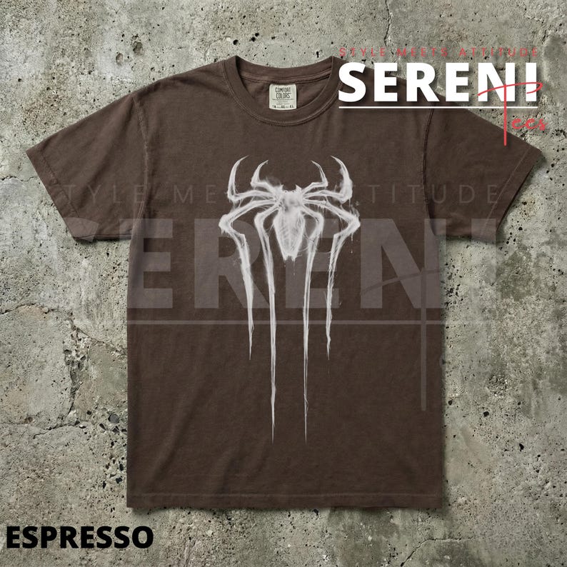 Puede incluir: Camiseta color espresso con un gr&aacute;fico de ara&ntilde;a blanco. El dise&ntilde;o incluye la palabra "SERENI" en rojo y blanco, y la palabra "ESPRESSO" en la parte inferior. La camiseta tiene cuello redondo y mangas cortas.
