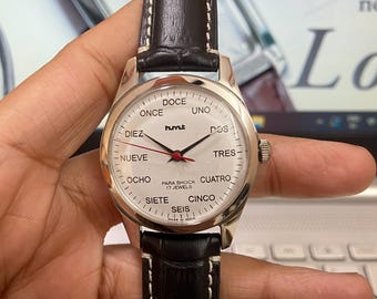 Reloj HMT Janata de cuerda manual con esfera española: 17 joyas, piel negra