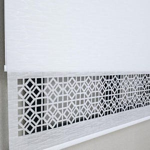 May include: White roller blind featuring a geometric diamond pattern at the bottom. The blind is made of a textured material and is partially rolled down, displaying the pattern. A modern, decorative window treatment.