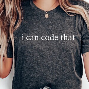 May include: Dark gray t-shirt with the text "i can code that" in white. The shirt is a crew neck style and is made of a soft material. The words "DARK GRAY" are at the bottom of the image.