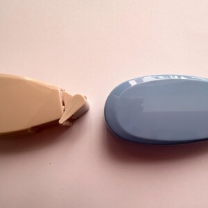Peut inclure: Deux distributeurs de ruban adh&eacute;sif, l'un beige et l'autre bleu clair, avec un design incurv&eacute; et une petite poign&eacute;e sur le c&ocirc;t&eacute;.