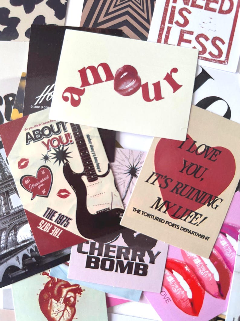 May include: A collection of various cards with text and graphics. One card reads "amour" with a lip graphic. Other cards feature phrases like "About You!", "Cherry Bomb", and "I Love You, It's Ruining My Life!" in red and black.