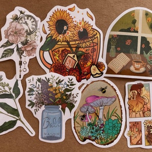 May include: A set of nine stickers featuring various floral and nature-themed designs. The stickers include a sunflower and teacup, a window with a teapot and book, a mason jar with flowers, mushrooms and succulents, a floral design with a clock, and a girl with sunflowers.