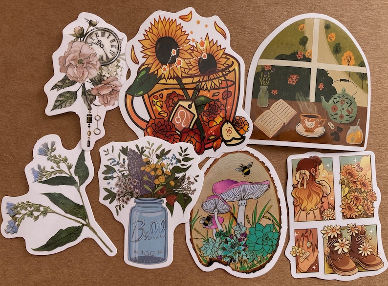 May include: A set of nine stickers featuring various floral and nature-themed designs. The stickers include a sunflower and teacup, a window with a teapot and book, a mason jar with flowers, mushrooms and succulents, a floral design with a clock, and a girl with sunflowers.