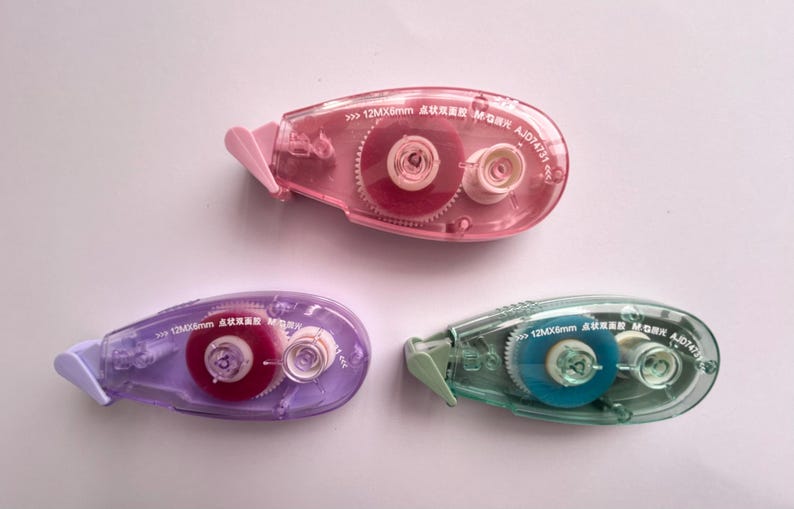 Peut inclure: Trois distributeurs de ruban adh&eacute;sif transparents avec des corps de couleurs diff&eacute;rentes&nbsp;: rose, violet et vert. Chaque distributeur a un rouleau de ruban adh&eacute;sif transparent et une petite poign&eacute;e. Les distributeurs de ruban adh&eacute;sif sont &eacute;tiquet&eacute;s avec le texte&nbsp;&laquo;&nbsp;12&nbsp;MMX6&nbsp;MM&nbsp;CORRECTION&nbsp;MODEL&nbsp;A07011&nbsp;&raquo;.