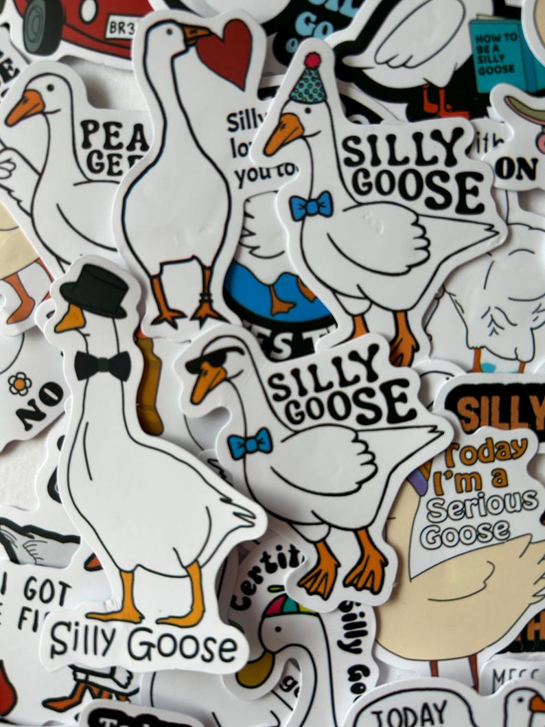 Puede incluir: Una colecci&oacute;n de pegatinas de gansos blancos con contornos negros y picos y patas naranjas. Algunos gansos llevan pajaritas, sombreros y gafas de sol. El texto en las pegatinas incluye "Silly Goose" y otras frases.