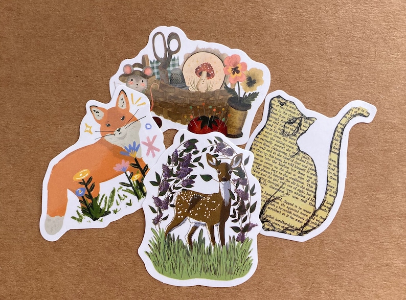 May include: Four illustrated stickers featuring a fox, a deer, a cat, and a sewing kit. The fox is orange and white, the deer is brown with white spots, the cat is yellow with black text, and the sewing kit is brown with red and white accents.