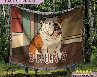 May include: Woven throw blanket featuring a seated bulldog with brown and white fur, and the name "BRUNO" in large letters. The background has a brown and beige color scheme. The blanket has a fringed edge.
