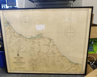 May include: Framed vintage nautical chart of the Songkhla to Kelantan region, featuring detailed coastlines, compass roses, and navigational information. The map is printed on aged paper and encased in a black frame, suitable for maritime enthusiasts.