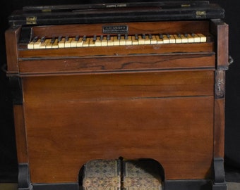 May include: Antique wooden pump organ with ivory-colored keys and a dark finish. The organ has a hinged top and decorative pedals. The name "A.B. Chase Co. Norwalk, O." is visible on the front. The instrument is a vintage musical item.