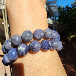May include: A double-strand bracelet made of blue gemstone beads. The beads are round and have a slightly iridescent finish.