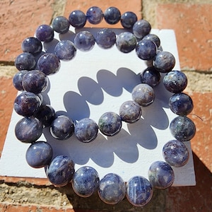 May include: A blue and purple gemstone bracelet made of round beads. The bracelet is made of natural stones and is a beautiful piece of jewelry.