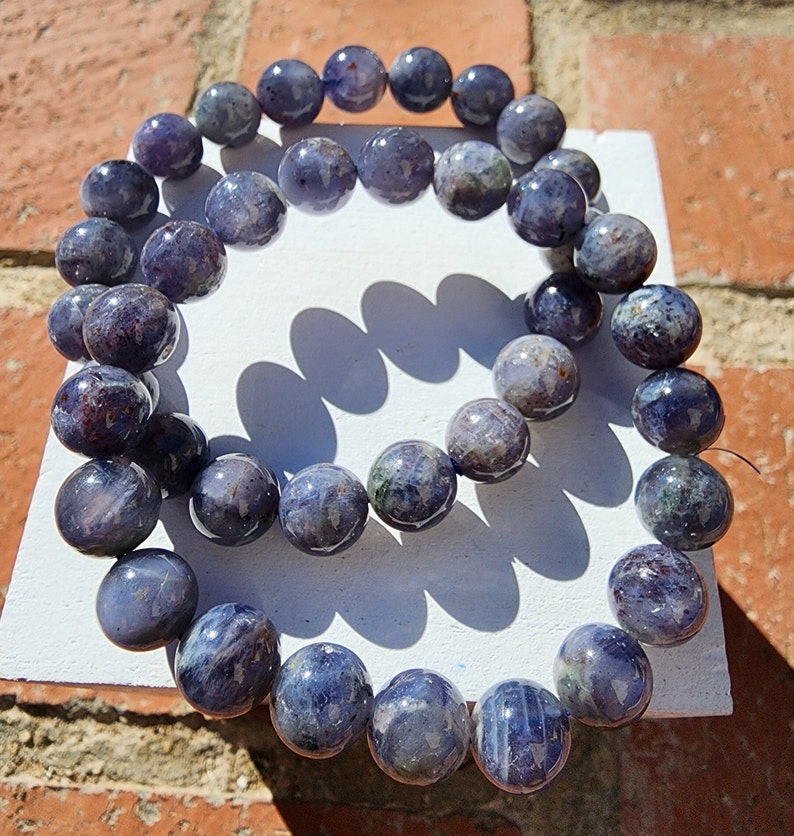 May include: A blue and purple gemstone bracelet made of round beads. The bracelet is made of natural stones and is a beautiful piece of jewelry.