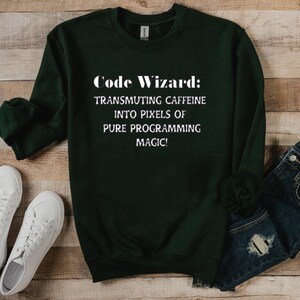May include: A dark green sweatshirt with the text "Code Wizard: Transmuting caffeine into pixels of pure programming magic!" printed in white.