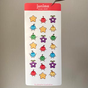 May include: A sticker sheet with colorful cartoon fruit and star designs. The stickers include yellow stars, red apples, purple stars, blue berries, green apples, and yellow berries. The sheet has the text "junimo sticker sheet" and "by @sophie.illustration".