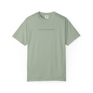 May include: Sage green t-shirt with the text "i can't, i have bookclub" in a simple, black font. The shirt has a crew neck and short sleeves. The fabric appears soft and comfortable, suitable for casual wear.