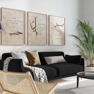 May include: Three framed prints with Arabic calligraphy and inspirational quotes about love, gratitude, and patience. The prints are hung on a white wall above a black sofa with brown throw pillows.