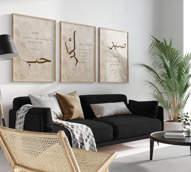 May include: Three framed prints with Arabic calligraphy and inspirational quotes about love, gratitude, and patience. The prints are hung on a white wall above a black sofa with brown throw pillows.