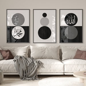 Peut inclure: Trois impressions encadr&eacute;es en noir et blanc avec des formes g&eacute;om&eacute;triques et de la calligraphie arabe. Les impressions sont accroch&eacute;es &agrave; un mur blanc au-dessus d'un canap&eacute; blanc avec des coussins de couleur marron.