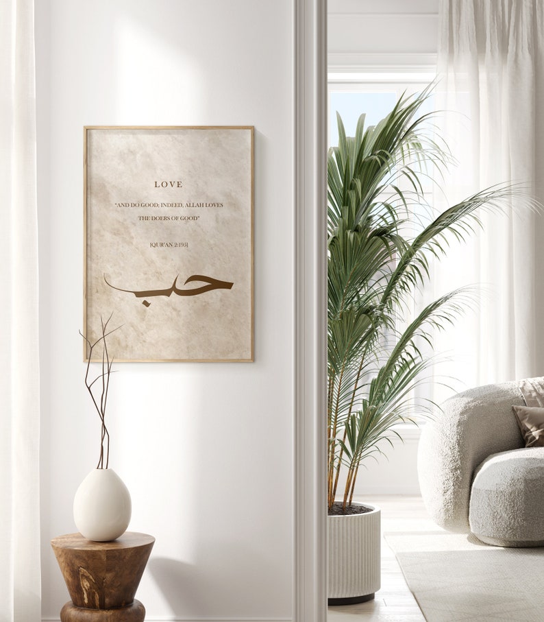 May include: A beige framed print with a brown Arabic calligraphy design and the text "LOVE" and "AND DO GOOD, INDEED ALLAH LOVES THE DOERS OF GOOD" and "QUR'AN 2:195".