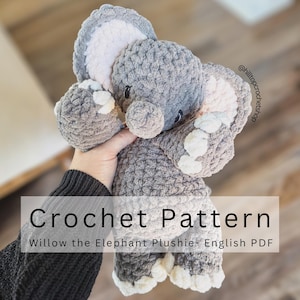 Op de afbeelding: Een gehaakte olifant knuffel in grijstinten, met witte accenten op de voeten en oren. De tekst "Crochet Pattern" en "Willow the Elephant Plushie- English PDF" staan op de afbeelding. De olifant is zacht en knuffelig.