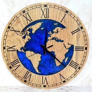 Può includere: Un orologio in legno con numeri romani e un design a mappa del mondo in resina blu al centro.