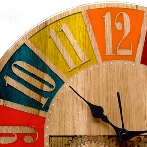 May include: A wooden clock face with colorful numbers and hands. The numbers are 10, 11, 12, and the clock hands are black.