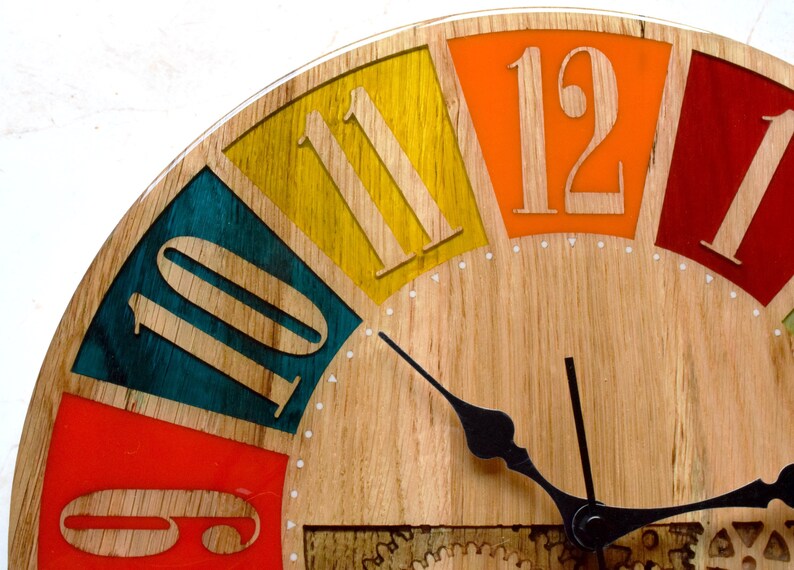 May include: A wooden clock face with colorful numbers and hands. The numbers are 10, 11, 12, and the clock hands are black.