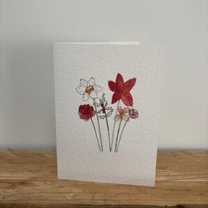 Una tarjeta de felicitación con flores de diciembre diseñada por ella, adecuada para un cumpleaños de diciembre o cualquier ocasión.