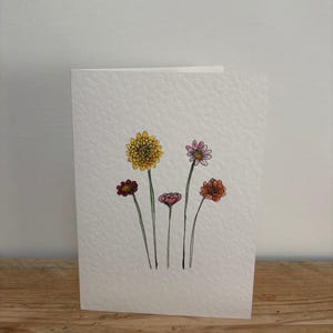 Una tarjeta de felicitación con flores de noviembre diseñada por ella, adecuada para un cumpleaños de noviembre o cualquier ocasión.