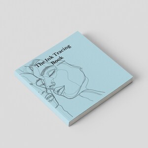 Può includere: Un libro quadrato con una copertina azzurra che presenta un'illustrazione a linee nere di due volti. Il testo sulla copertina recita The Ink Tracing Book e sotto, Karen Rebecca. Il libro è mostrato da una prospettiva angolata.