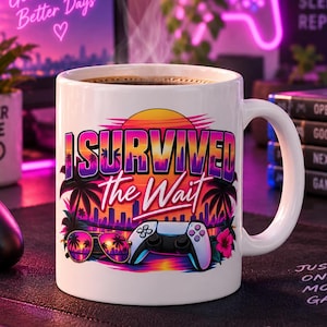 Könnte beinhalten: Ein weißer Keramikbecher mit einer farbenfrohen Grafik im Retro-Stil, die einen Sonnenuntergang, Palmen, eine Sonnenbrille und einen Gamecontroller zeigt. Der Text I SURVIVED the Wait ist in fetten violetten und weißen Buchstaben gedruckt.