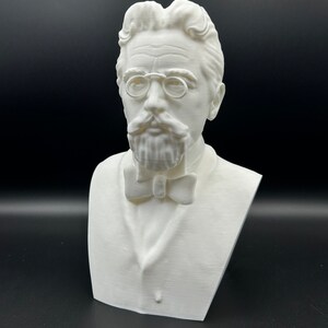 May include: A white 3D printed bust of a man with a mustache and glasses wearing a bow tie.