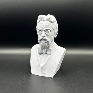 May include: A white 3D printed bust of a man with a mustache and glasses wearing a bow tie.