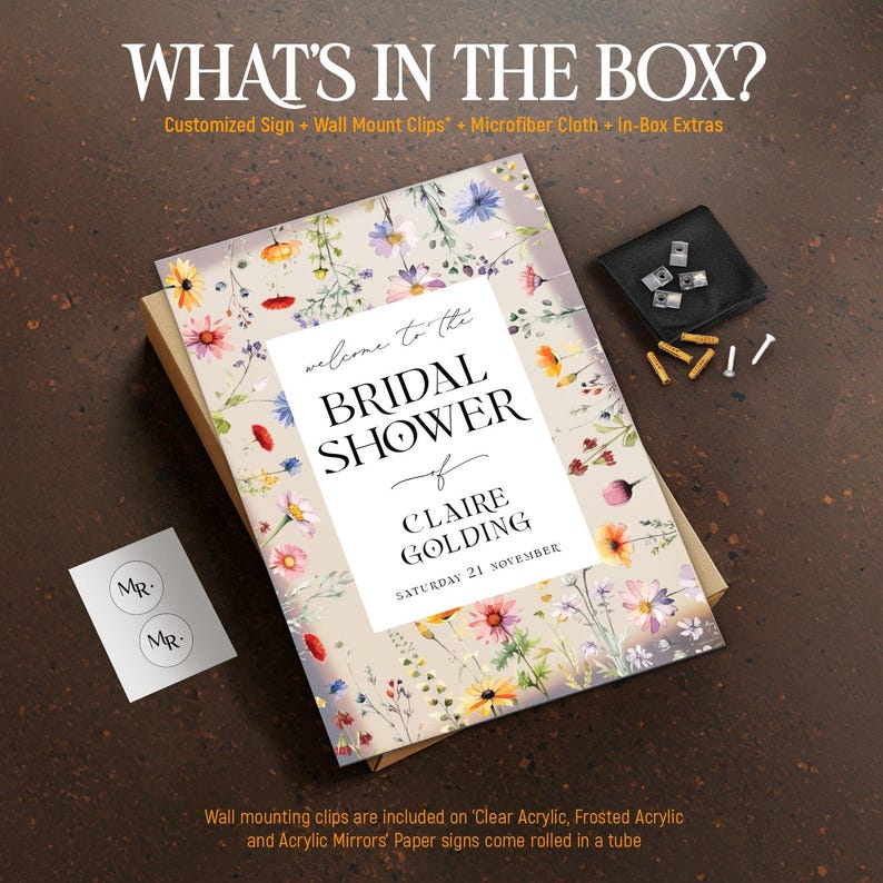May include: A rectangular bridal shower sign featuring a floral pattern with colorful wildflowers on a beige background. The text reads Welcome to the BRIDAL SHOWER of CLAIRE GOLDING SATURDAY 21 NOVEMBER. Includes wall mount clips and a small card.