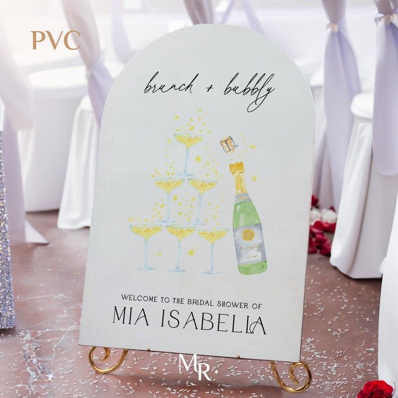 May include: A white sign with a champagne tower and bottle illustration. The sign reads "brunch + bubbly" and "Welcome to the bridal shower of MIA ISABELLA".