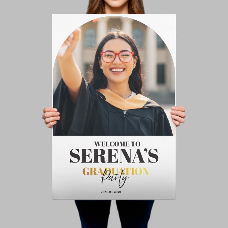 May include: A graduation party sign held by a person. The sign features a photo of a smiling graduate in a cap and gown. Text on the sign reads "WELCOME TO SERENA'S GRADUATION Party" with the date "JUNE 01, 2020".