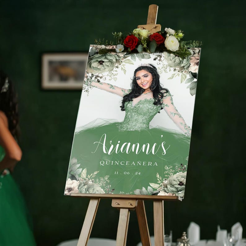 May include: A green and white welcome sign with floral designs and a photo of a young woman in a green dress. The sign reads "Arianne's Quinceanera 11.06.24".