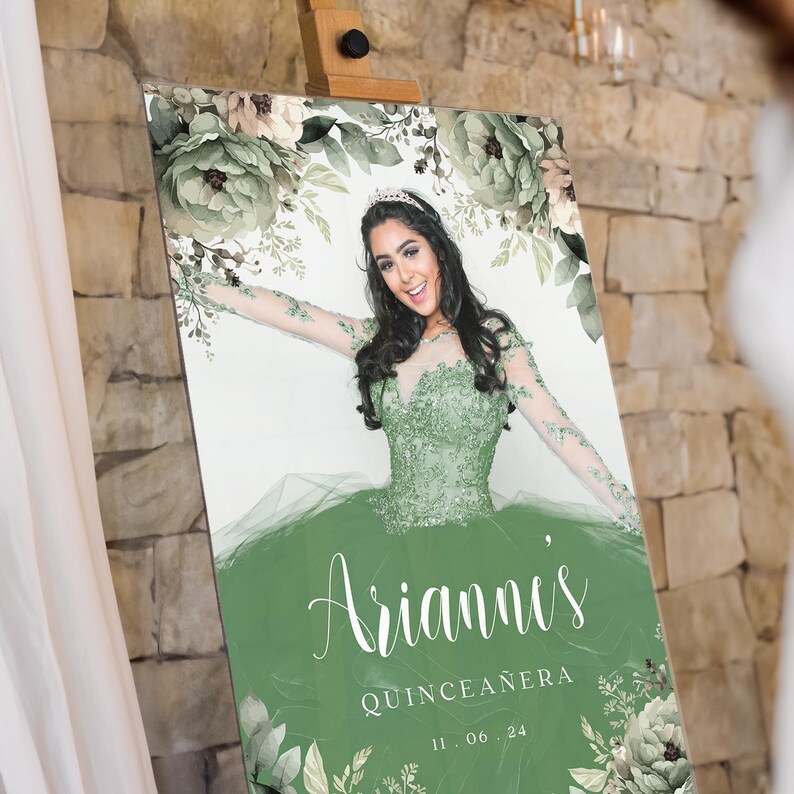May include: A green and white floral design with a photo of a young woman in a green dress. The text "Arianna's Quincea&ntilde;era 11.06.24" is printed on the sign.