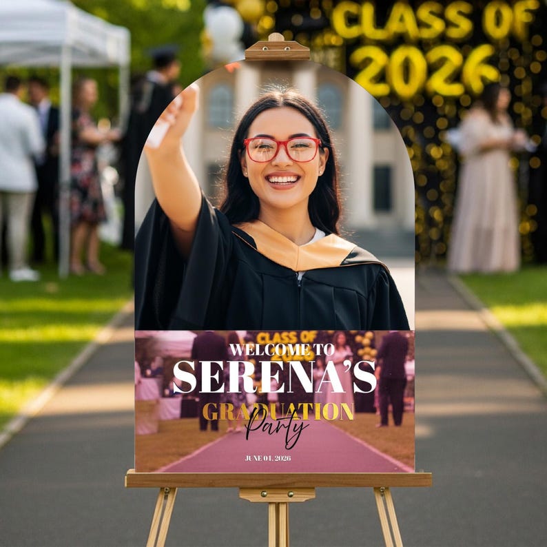 May include: A graduation party sign on a wooden easel. The sign features a photo of a smiling graduate in a cap and gown. The sign reads "Welcome to Serena's Graduation Party" with the date June 01, 2026.