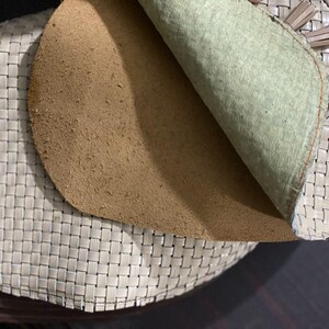 May include: Close-up of a woven leather shoe with a light beige color. The interior reveals a tan suede insole and a light green lining. The shoe's design features a basket weave pattern.