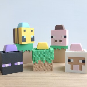 May include: Five Minecraft character figurines, each with a different head and body. The characters are a bee, a pig, a sheep, a creeper, and a villager. The figurines are made of plastic and are about 5 cm tall.