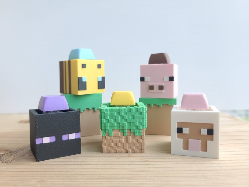 K&ouml;nnte beinhalten: F&uuml;nf Minecraft-Charakterfiguren, jede mit einem anderen Kopf und K&ouml;rper. Die Charaktere sind eine Biene, ein Schwein, ein Schaf, ein Creeper und ein Dorfbewohner. Die Figuren sind aus Kunststoff und etwa 5 cm gro&szlig;.