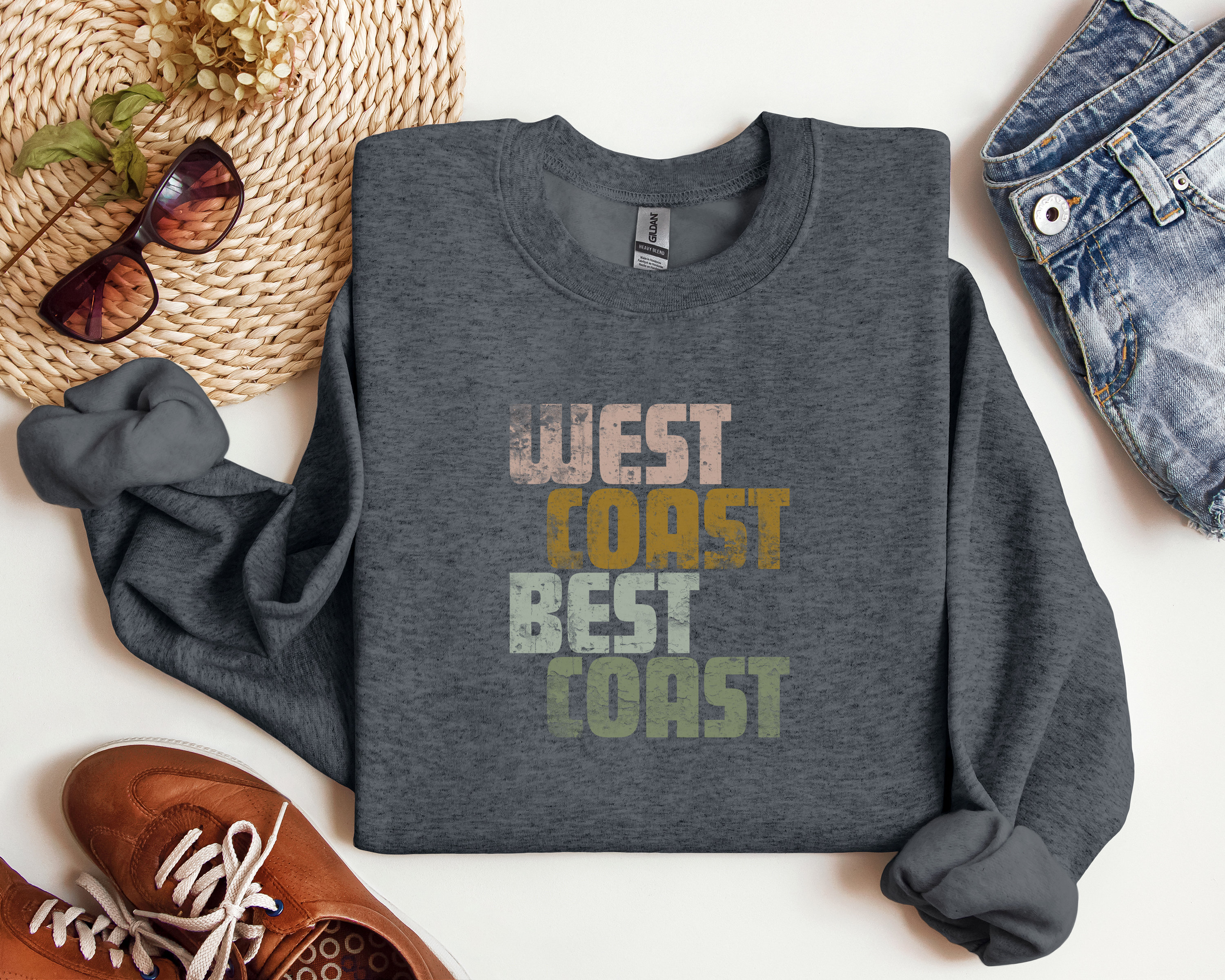 Może przedstawiać: Szara bluza z nadrukiem "West Coast Best Coast" w stylu vintage. Tekst jest w odcieniach r&oacute;żowego, ż&oacute;łtego, pomarańczowego i zielonego.