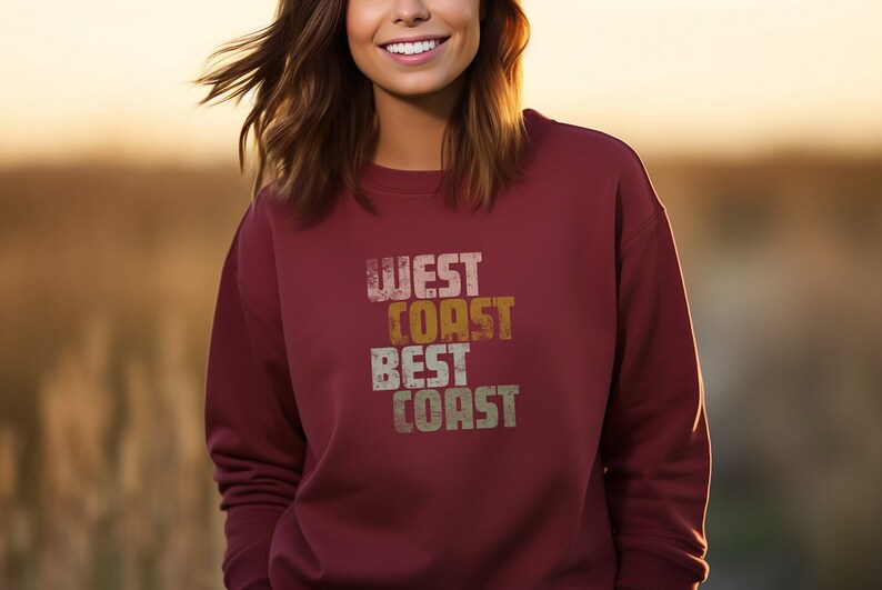 Może przedstawiać: Bordowa bluza z nadrukiem w stylu vintage, kt&oacute;ry głosi "West Coast Best Coast".