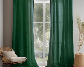 May include: A pair of dark green linen curtains hanging in a window. The curtains are fully drawn and the fabric has a subtle texture.